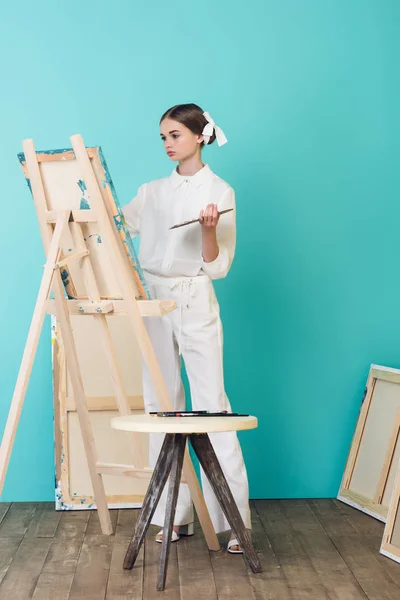 Teen artist painting on easel in workshop — Stock Photo