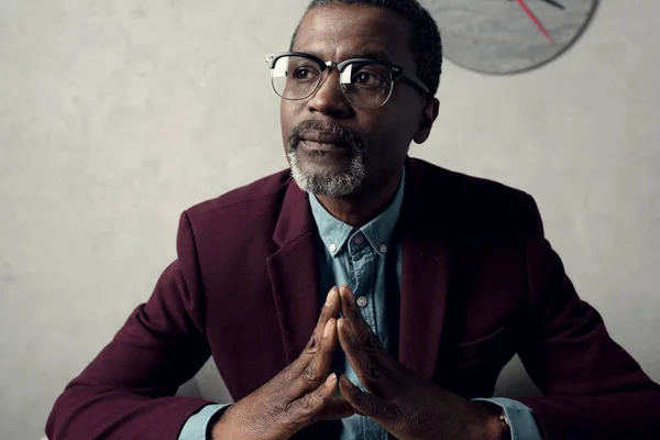 Portrait of pensive mature african american man in eyeglasses and burgundy jacket — Stock Photo