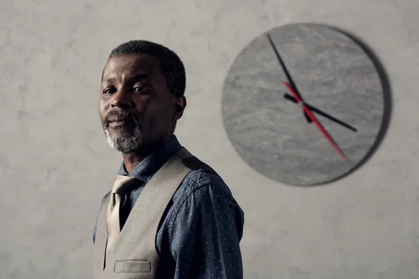 Retrato de homem americano africano elegante em colete com relógio na parede — Fotografia de Stock