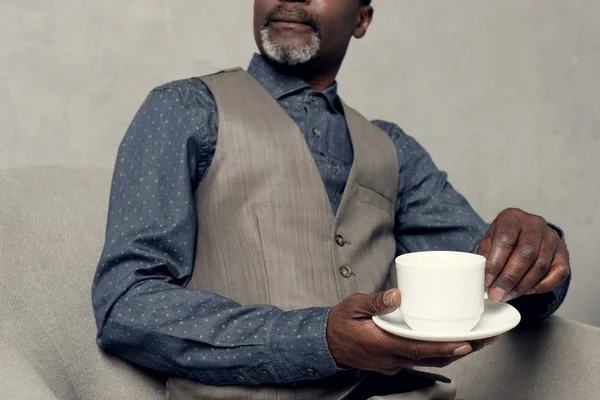 Abgeschnittene Ansicht von stilvollen afrikanisch-amerikanischen Mann in Weste hält Tasse Kaffee — Stockfoto