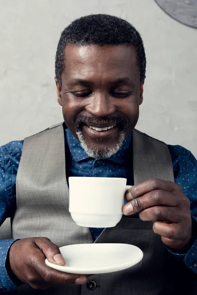 Portrait d'un homme afro-américain souriant en gilet avec tasse de café — Photo de stock
