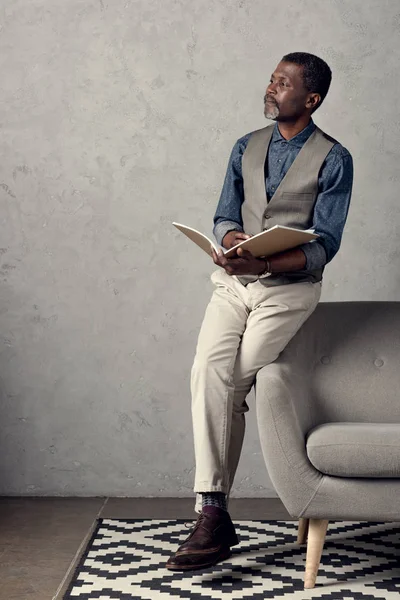 Thoughtful stylish african american businessman writing in planner — Stock Photo