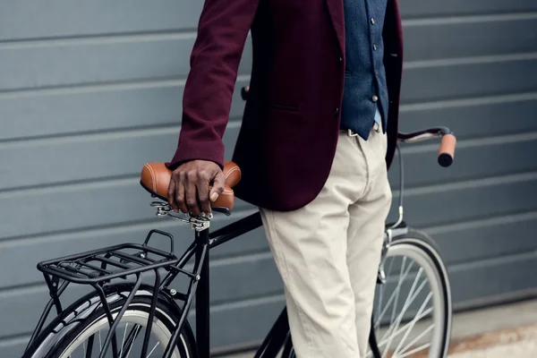 Vista ritagliata di elegante uomo africano americano appoggiato sulla bicicletta — Foto stock