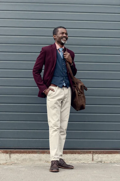 Hombre afroamericano de mediana edad con estilo con bolsa de cuero - foto de stock