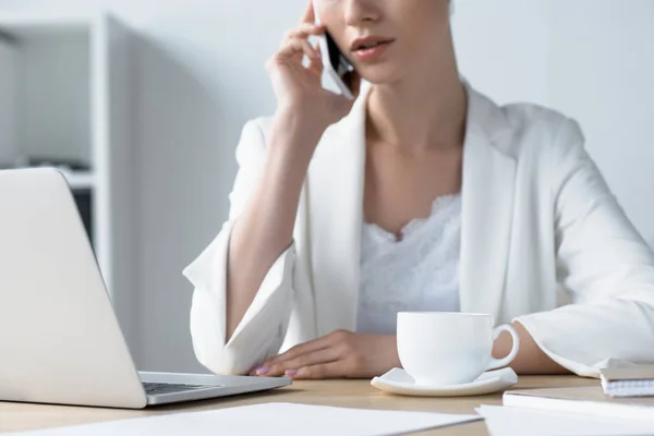 Cropped shot of young businesswoman talking by phone at office — Stock Photo