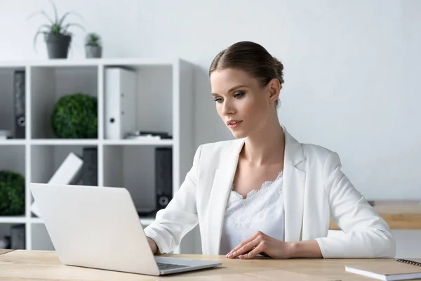 Concentrada jovem empresária que trabalha com laptop no escritório — Stock Photo