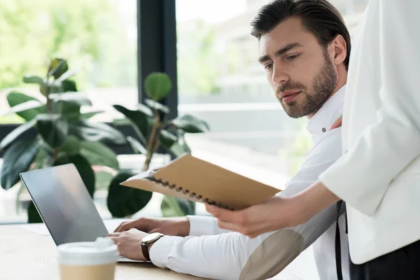 Recortado tiro de secretaria mostrando notas a jefe en la oficina — Stock Photo