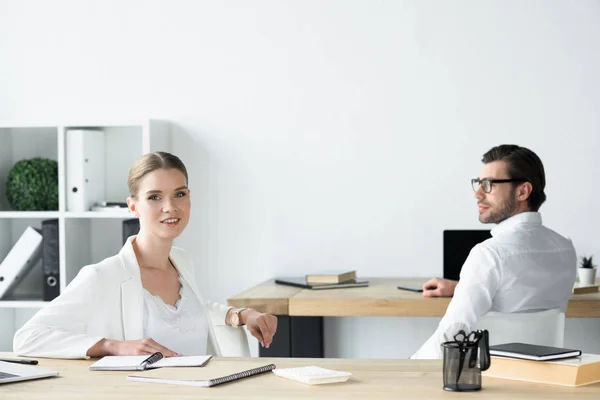 Young business colleagues sitting at workplace in office — Stock Photo