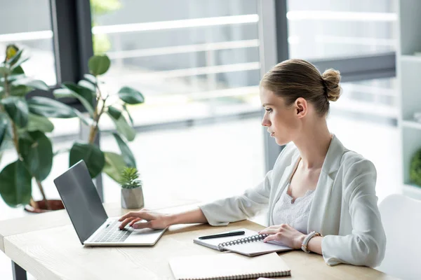 Jovem empresária confiante trabalhando com laptop no escritório — Stock Photo