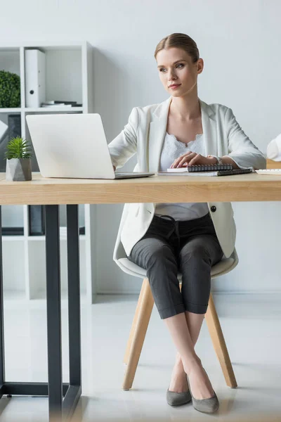 Belle jeune femme d'affaires travaillant avec ordinateur portable au bureau moderne — Photo de stock