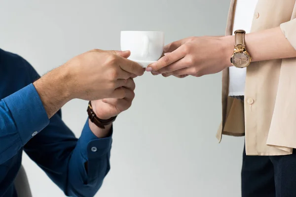 Abgeschnittene Aufnahme einer Sekretärin, die ihrem Chef eine Tasse Kaffee reicht, isoliert auf Weiß — Stockfoto