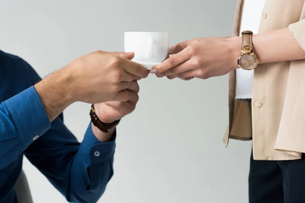 Recortado disparo de secretario pasando taza de café a jefe aislado en blanco - foto de stock