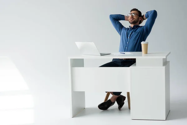 Feliz joven hombre de negocios relajarse en el lugar de trabajo en blanco - foto de stock