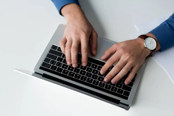 Plan recadré de l'homme travaillant avec un ordinateur portable sur la surface blanche — Photo de stock