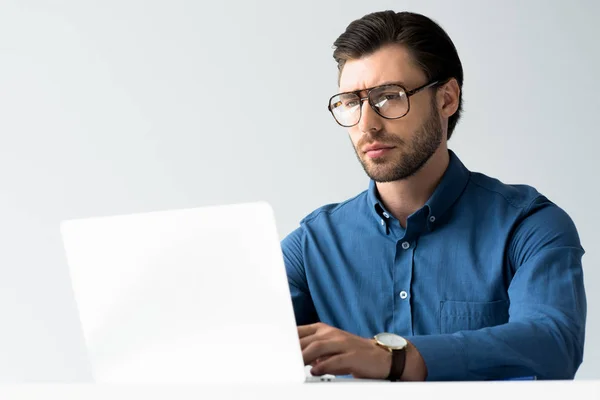 Красивий молодий бізнесмен працює з ноутбуком ізольовано на білому — стокове фото