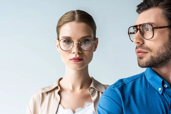 Ritratto ravvicinato di giovane uomo e donna in abiti eleganti e occhiali isolati su bianco — Foto stock