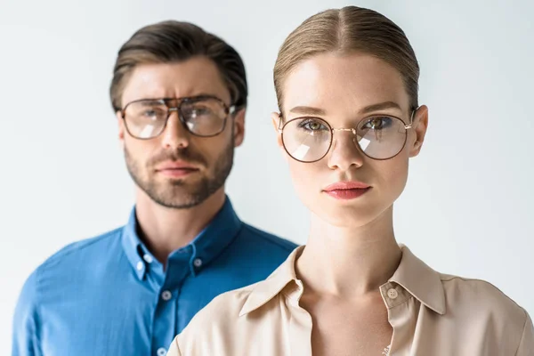 Ritratto ravvicinato di attraente giovane uomo e donna in abiti eleganti e occhiali isolati su bianco — Foto stock