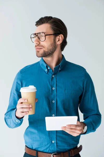 Fiducioso giovane con tazza di carta di caffè e tablet isolato su bianco — Foto stock