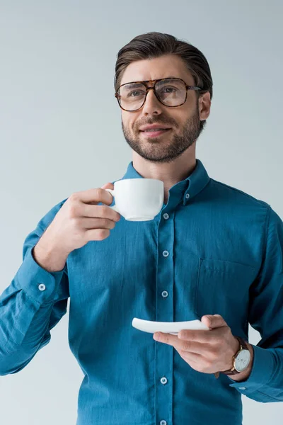 Привабливий молодий чоловік з чашкою кави ізольований на білому — стокове фото
