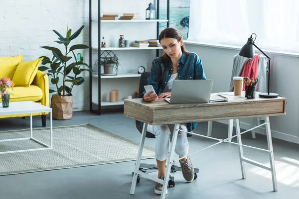 Mädchen nutzt Smartphone beim Lernen mit Laptop zu Hause — Stockfoto