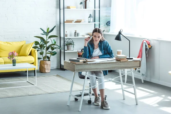 Konzentriertes Teenager-Mädchen sitzt am Schreibtisch und lernt zu Hause — Stockfoto