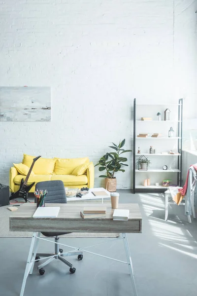 Современный интерьер с деревянным столом и уютным желтым диваном — стоковое фото