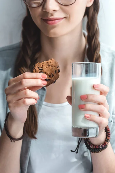 Cropped view of girl with cookie and milk in glass — Stock Photo