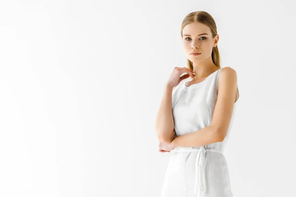 Mulher atraente em linho vestido branco posando com a mão no pescoço isolado no fundo cinza — Fotografia de Stock