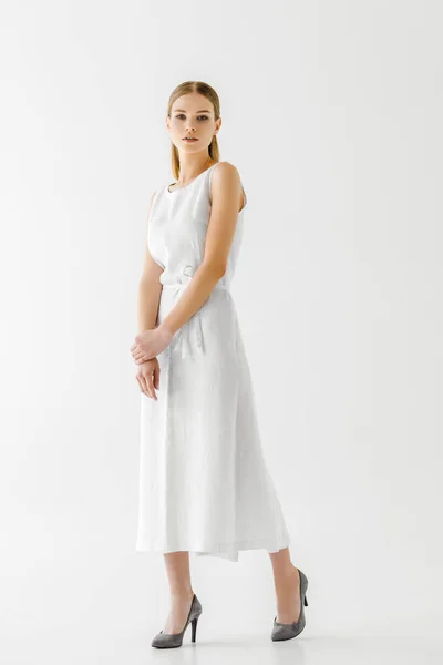 Hermoso modelo femenino en lino vestido blanco posando aislado sobre fondo gris - foto de stock