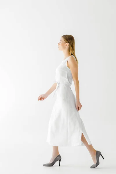 Vista lateral de hermosa mujer en vestido blanco de lino aislado sobre fondo gris - foto de stock