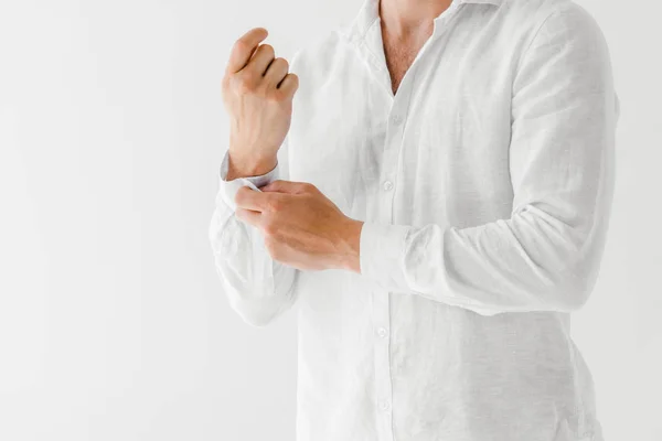 Обрезанное изображение человека в льняной белой рубашке на сером фоне — стоковое фото