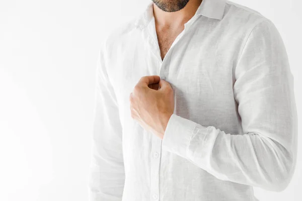 Cropped image of male model unbuttoning linen white shirt isolated on grey background — Stock Photo