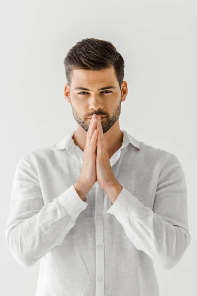 Portrait of man in linen clothes holding hand palms together isolated on grey background — Stock Photo