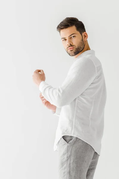 Mann in leinenweißem Hemd blickt vereinzelt in die Kamera auf grauem Hintergrund — Stockfoto
