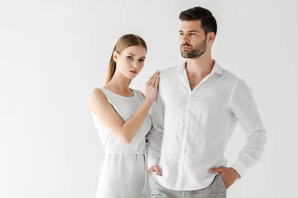 Attraente donna in lino abito bianco abbracciando fidanzato con le mani in tasche isolate su sfondo grigio — Foto stock