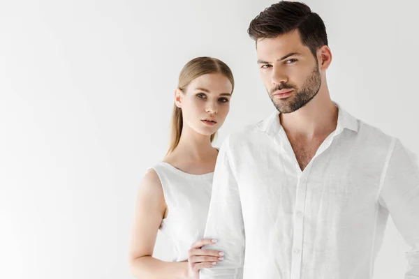 Hermosa mujer en lino vestido blanco abrazando novio aislado sobre fondo gris - foto de stock