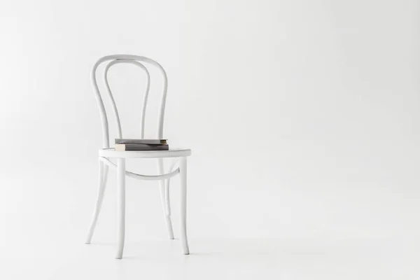 Front view of chair with two books isolated on grey background — Stock Photo