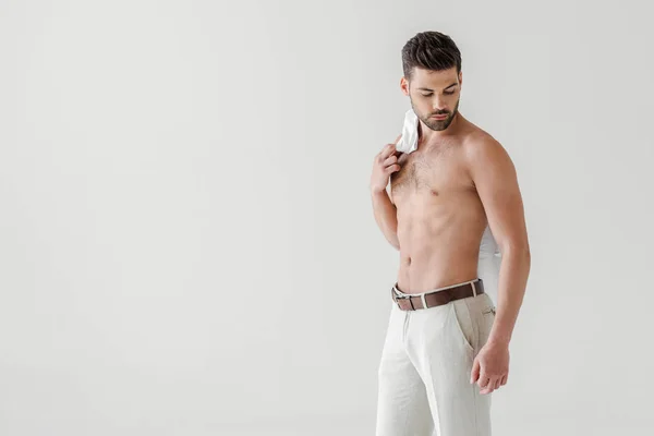 Hombre guapo en topless posando con camisa en el hombro aislado sobre fondo gris - foto de stock