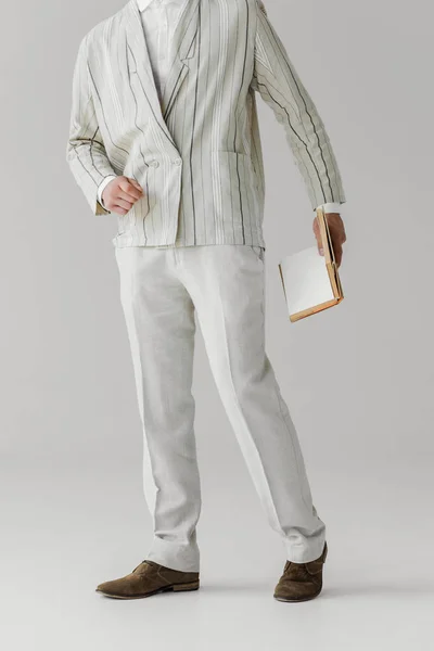 Обрізаний знімок людини в легкому костюмі з книгою на білому — стокове фото