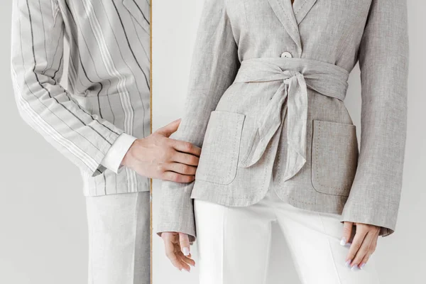 Cropped shot of man in vintage jacket touching his girlfriend from behind white wall — Stock Photo