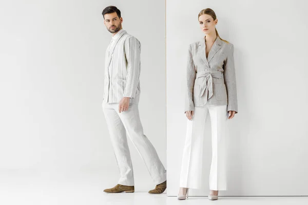 Young male and female models in vintage clothes looking at camera on white — Stock Photo