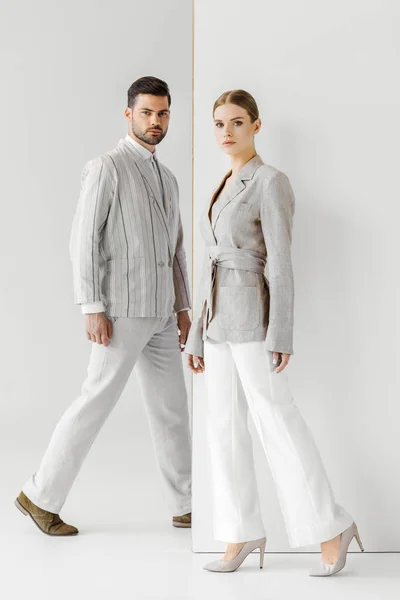 Young male and female models in vintage clothes walking and looking at camera on white — Stock Photo