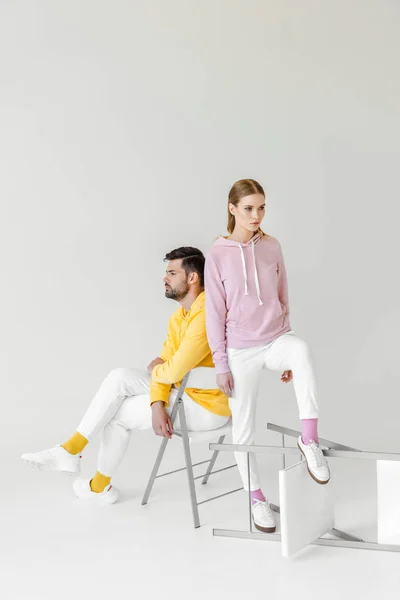 Young male and female models in stylish hoodies on white — Stock Photo