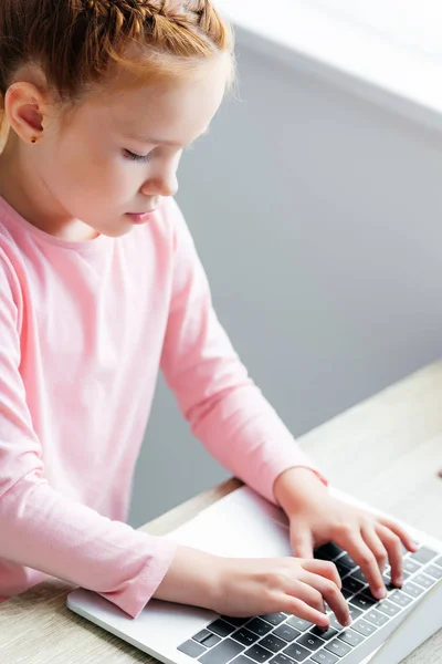 Vista ad alto angolo di bella scolaretta utilizzando il computer portatile — Foto stock