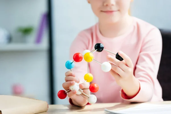 Recortado disparo de sonriente escolar celebración de modelo molecular - foto de stock