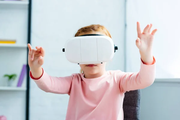 Adorabile piccola studentessa utilizzando auricolare realtà virtuale a casa — Foto stock