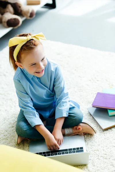 High angle view of smiling redhead child studying with laptop at home — Stock Photo