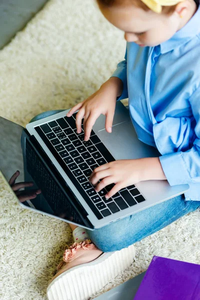 Plan recadré de petit enfant à l'aide d'un ordinateur portable avec écran blanc à la maison — Photo de stock