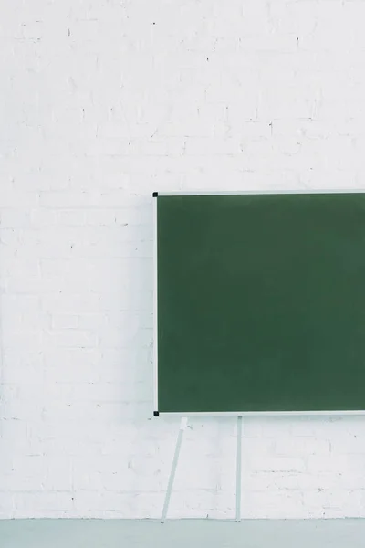 Blank chalkboard and white brick wall — Stock Photo