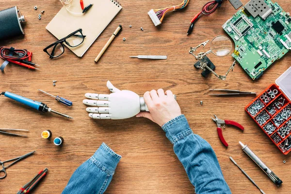 Image recadrée de l'homme amputé tenant un bras prothétique à la main — Photo de stock